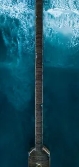 Aerial view of a long bridge crossing over turquoise ocean waves.