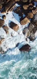 Aerial view of waves crashing on rugged coastal rocks.