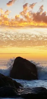 Waves crash against rocks at sunset with orange sky.