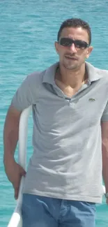 Person enjoying the ocean breeze against turquoise waters.