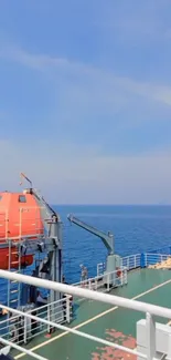 View of ship deck overlooking vast blue ocean and sky.