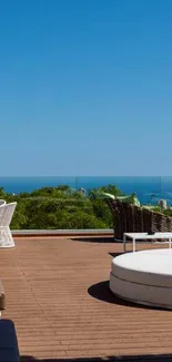 Ocean view rooftop with loungers and greenery under clear blue skies.