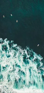 Aerial view of ocean waves with surfers, capturing dynamic teal and white tones.