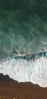 Aerial view of turquoise ocean waves crashing onto a sandy beach.