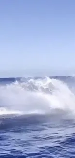 Vibrant ocean wave splash against a clear blue sky for mobile wallpaper.