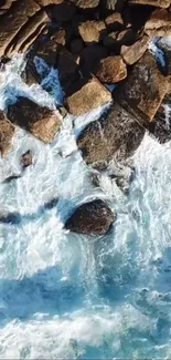 Aerial view of ocean waves crashing against rocky coastline wallpaper.