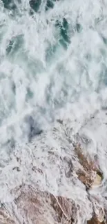 Aerial view of ocean waves crashing against rocky shore creating white foam.