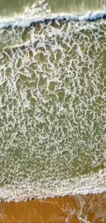 Aerial view of ocean waves and sandy shore in soothing seafoam green.