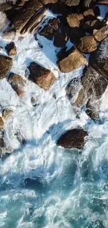 Aerial view of ocean waves hitting rocks with blue and white colors.