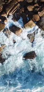 Wallpaper of ocean waves hitting rocks from above.