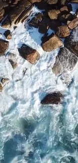 Breathtaking ocean waves crashing against rocky shore from above.