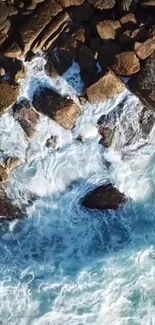 Aerial view of ocean waves crashing on rocky shore. Vibrant blue seascape wallpaper.