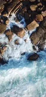 Aerial view of ocean waves hitting rocky shore with blue and earthy tones.