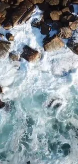 Aerial view of ocean waves crashing against rocky coastline with clear blue water.