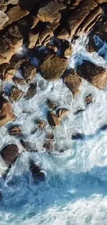 Aerial view of ocean waves crashing over rugged rocks.