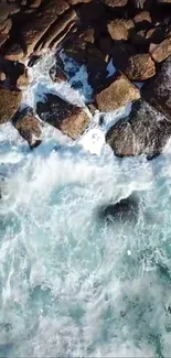 Aerial view of ocean waves crashing on rugged rocks.