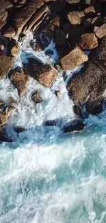 Aerial view of ocean waves crashing against rocky shore.