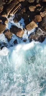 Aerial view of waves crashing on rocky shore, vibrant blue ocean.