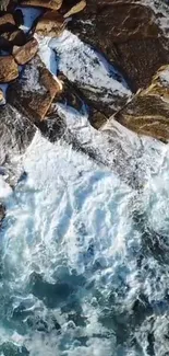 Aerial view of ocean waves crashing onto rocky coastline, showcasing water splashes.