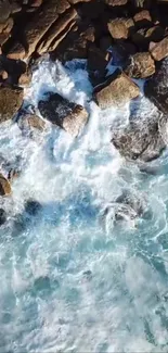 Aerial view of ocean waves crashing onto a rocky shoreline, creating a serene beach scene.