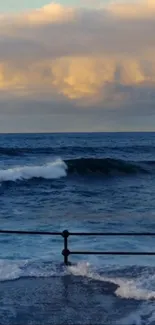 Ocean waves crashing at sunset against a vibrant sky.