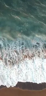 Aerial view of ocean waves meeting sandy beach.