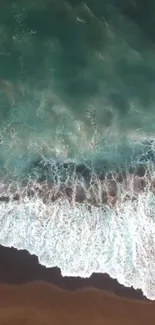 Aerial view of ocean waves crashing on a sandy beach.