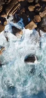 Aerial view of ocean waves crashing on rugged coastal rocks.