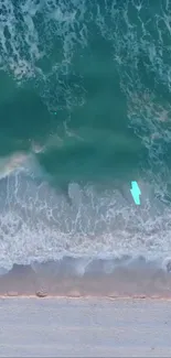 Aerial view of ocean waves crashing onto a sandy beach, ideal for mobile wallpaper.