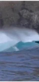 Ocean wave crashing on rocky shore with blue water and white foam.