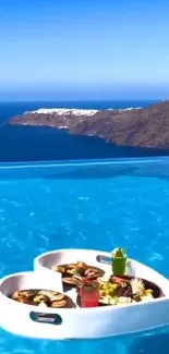 Infinity pool with ocean view and breakfast tray.