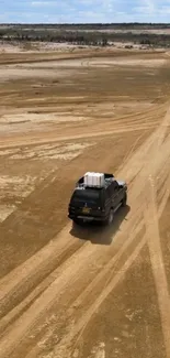 Two vehicles drive on a desert trail.