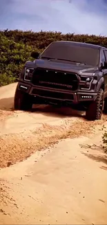 Off-road truck driving through sandy terrain with green foliage in the background.