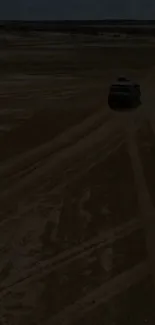 Off-road vehicle on a sandy desert path with clear sky.