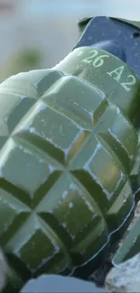 Close-up of an olive green grenade with detailed patterns for unique wallpaper.