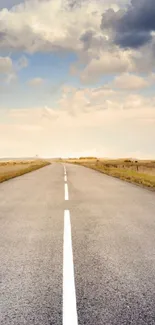 Open road beneath a vast, cloudy sky with scenic views stretching ahead.