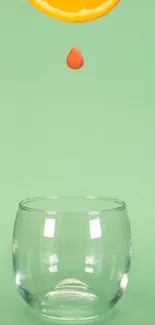 Mint background with glass and orange slice drop, minimalist style