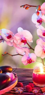 Serene mobile wallpaper with pink orchids and a glowing candle.