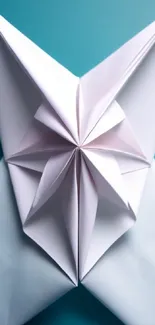 Folded white origami butterfly on a teal blue background.