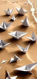 Origami paper boats scattered on a sandy beach with gentle waves.