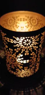 Ornate candle holder casting warm glow with floral pattern.