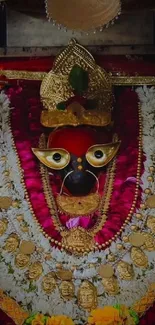 Traditional deity adorned with ornate jewelry and flowers.