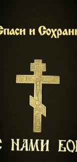 Orthodox cross with gold lettering on dark wallpaper.