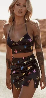 Woman in butterfly dress walking outdoors with desert background.