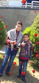 Kids smiling with thumbs up outdoors amidst greenery.