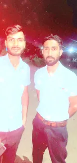 Two men in light shirts standing under streetlights at night.