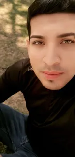 Close-up portrait of a person sitting outdoors in a peaceful setting.