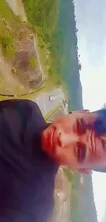 Selfie with green hills and cloudy sky background.