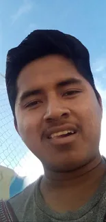 A selfie taken on a sunny day with a clear blue sky in the background.