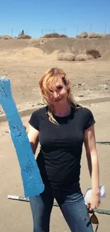 Person with a blue foam hand in a desert setting.